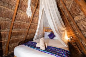 Una cama en una tienda con un animal de peluche. en Nílu Isla Mujeres by Selina, en Isla Mujeres