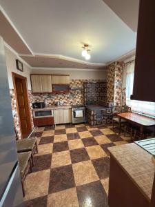 cocina grande con suelo a cuadros en Карпатський Дивокрай, en Perekrestnoye