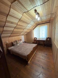 Un dormitorio con una cama grande con techo de madera. en Карпатський Дивокрай, en Perekrestnoye