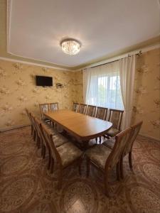 Un comedor con mesa y sillas de madera. en Карпатський Дивокрай, en Perekrestnoye