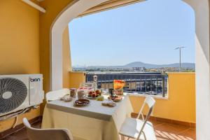 une salle à manger avec une table et une grande fenêtre dans l'établissement Terrace with View - Olbia Pasana, à Olbia