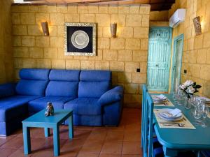 a living room with a blue couch and tables at casacarmo in Carmona