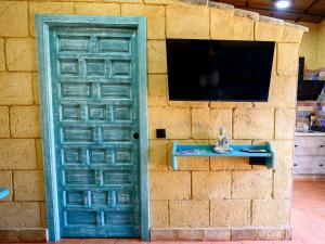 a blue door with a television on a brick wall at casacarmo in Carmona