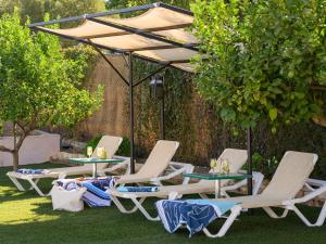 a group of chairs and tables under an umbrella at casacarmo in Carmona