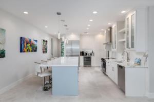 a kitchen with white cabinets and a large white island at A Saba Wind North- Oceanfront Estate with Pool on Captiva Island in Captiva +13 photos