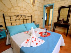 a bedroom with a blue bed with red flowers on it at casacarmo in Carmona +31 photos