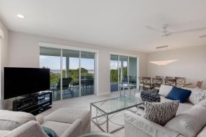 a living room with a couch and a flat screen tv at A Saba Wind North- Oceanfront Estate with Pool on Captiva Island in Captiva