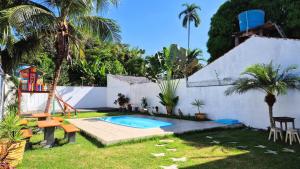 a backyard with a swimming pool and a playground at Recanto das Palmeiras Alter do Chão in Alter do Chao