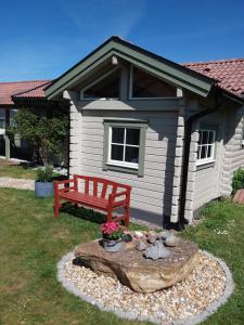 a red bench sitting in front of a house at Furusol Borgholm in Borgholm