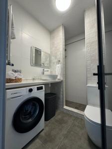 une salle de bains avec lave-linge et lavabo dans l'établissement Современные апартаменты на Магнитных песках, à Urekis Sadguri