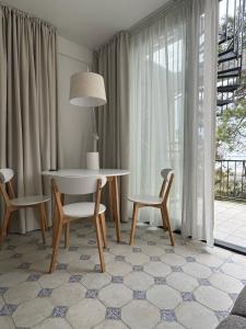 une salle à manger avec une table et des chaises et une fenêtre dans l'établissement Современные апартаменты на Магнитных песках, à Urekis Sadguri