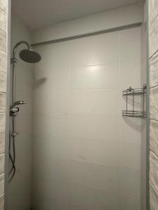 La salle de bains est pourvue d'une douche et d'un mur en carrelage. dans l'établissement Современные апартаменты на Магнитных песках, à Urekis Sadguri 7 autres photos