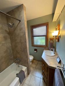a bathroom with a tub and a toilet and a sink at Farmhouse Cabin in the Redwoods in Eureka