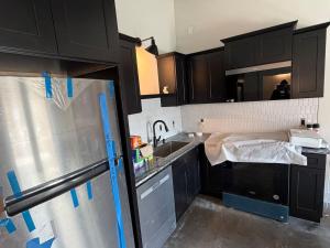 a kitchen with black cabinets and a sink at The Dim Light - One Bedroom in Paducah
