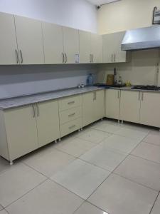 a kitchen with white cabinets and white tile floors at Caspian in Baku