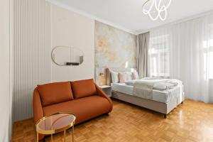a bedroom with a bed and a couch at Near Schönbrunn I 1 Min to U6 Niederhofstraße in Vienna