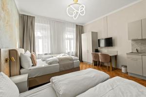 a hotel room with two beds and a desk at Near Schönbrunn I 1 Min to U6 Niederhofstraße in Vienna