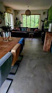 a living room with a couch and a table at Villa in the forest of Amsterdam with Pool in Velsen-Zuid