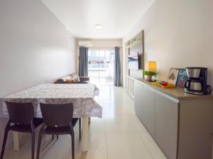 een keuken met een tafel en stoelen in een kamer bij Curta Praia de Armação - Casa Violeta in Penha