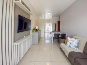 een woonkamer met een bank en een televisie bij Curta Praia de Armação - Casa Violeta in Penha