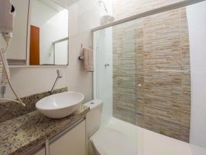 een badkamer met een wastafel en een glazen douche bij Curta Praia de Armação - Casa Violeta in Penha +111 foto's