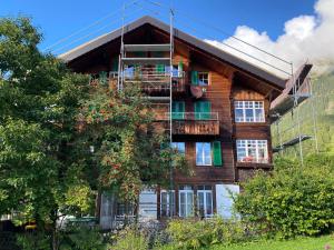 Cette maison en bois dispose d'un balcon sur le côté. dans l'établissement Staubbachbänkli, à Wengen