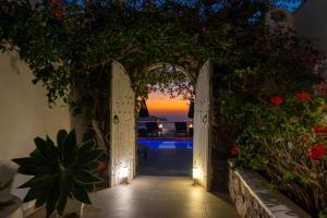 an open door with a view of the ocean at sunset at Athermi Suites - Adults Only in Megalokhori +51 photos