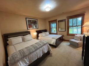 a large bedroom with two beds and a chair at Luxe Artful Mountain Retreat with 4 King Suites, 8 Person Hot Tub and 3 Decks in Carbondale