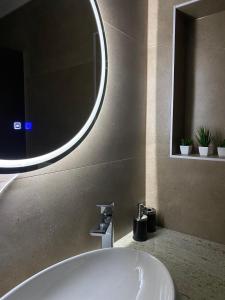 a bathroom with a white sink and a mirror at Villa Vratnica - Restaurant & Apartments in Vratnica