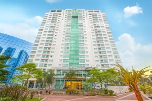 a tall white building with trees in front of it at Saint Moritz Hplus Express in Brasilia