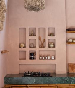 a kitchen with a stove and shelves on the wall at Villa Pinkaboo - Gorgeous and Luxury One-Bedroom Villa in the Heart of Canggu in Canggu