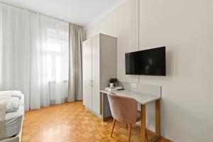 a room with a desk and a tv on a wall at Meidling Rooms I 1 Min to U6 I Self Check In in Vienna