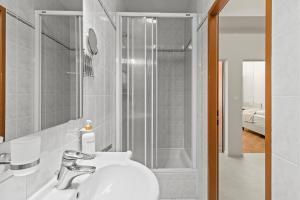 a white bathroom with a shower and a sink at Near Schönbrunn I 1 Min to U6 Niederhofstraße in Vienna