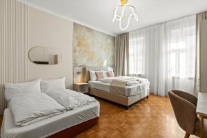 a bedroom with two beds and a chandelier at Meidling Rooms I 1 Min to U6 I Self Check In in Vienna
