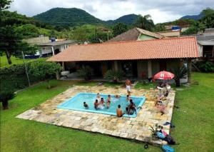 a group of people in a swimming pool in a yard at Sítio Serra Verde in Guapimirim