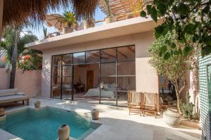 a house with a swimming pool in a yard at Villa Pinkaboo - Gorgeous and Luxury One-Bedroom Villa in the Heart of Canggu in Canggu