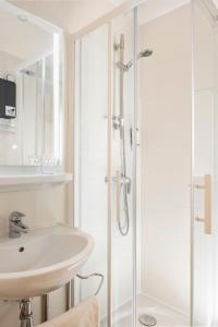 a bathroom with a sink and a shower at Hôtel Le Nautilus in Saint Malo +31 photos