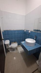 Un baño con azulejos azules, inodoro y lavabo. en LAS OLAS, en Paraíso 8 fotos más