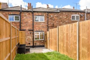 a house with a wooden fence in front of it at Beautiful Cottage with a modern twist! in Redbourn