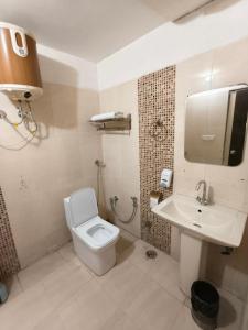 Un baño con un inodoro blanco y un lavabo. en Hind Hotel Near Airport Road Mohali Zirakpur, en Zirakpur