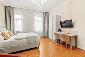 a bedroom with a bed and a desk and a television at Meidling Rooms I 1 Min to U6 I Self Check In in Vienna