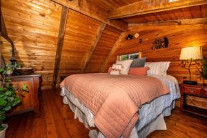 une chambre avec un lit dans une cabane en rondins dans l'établissement Two Bedroom Log Cabin, à Unionville