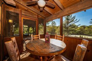 une salle à manger avec une table et des chaises dans une cabine dans l'établissement Two Bedroom Log Cabin, à Unionville