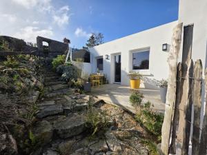 a stone path leading to a white house at Joli cocon vue mer exceptionnelle proche plages in Plouguerneau
