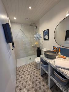 a bathroom with a sink and a toilet and a shower at Joli cocon vue mer exceptionnelle proche plages in Plouguerneau