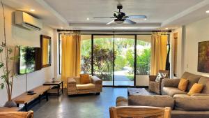 a living room with a couch and a ceiling fan at Monte Carlo Luxury Condominiums in Jacó