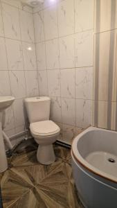 a bathroom with a toilet and a bath tub at Dostoievski 4 in Bălţi