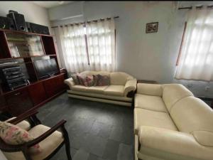 a living room with a couch and a tv at Sítio Serra Verde in Guapimirim
