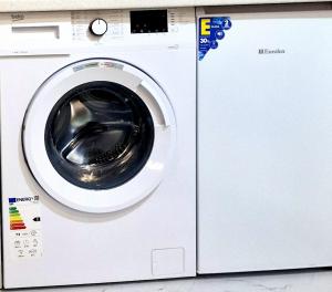 a white washing machine sitting next to a counter at Dostoievski 4 in Bălţi