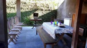 a patio with a table and benches and a grill at Sítio Serra Verde in Guapimirim